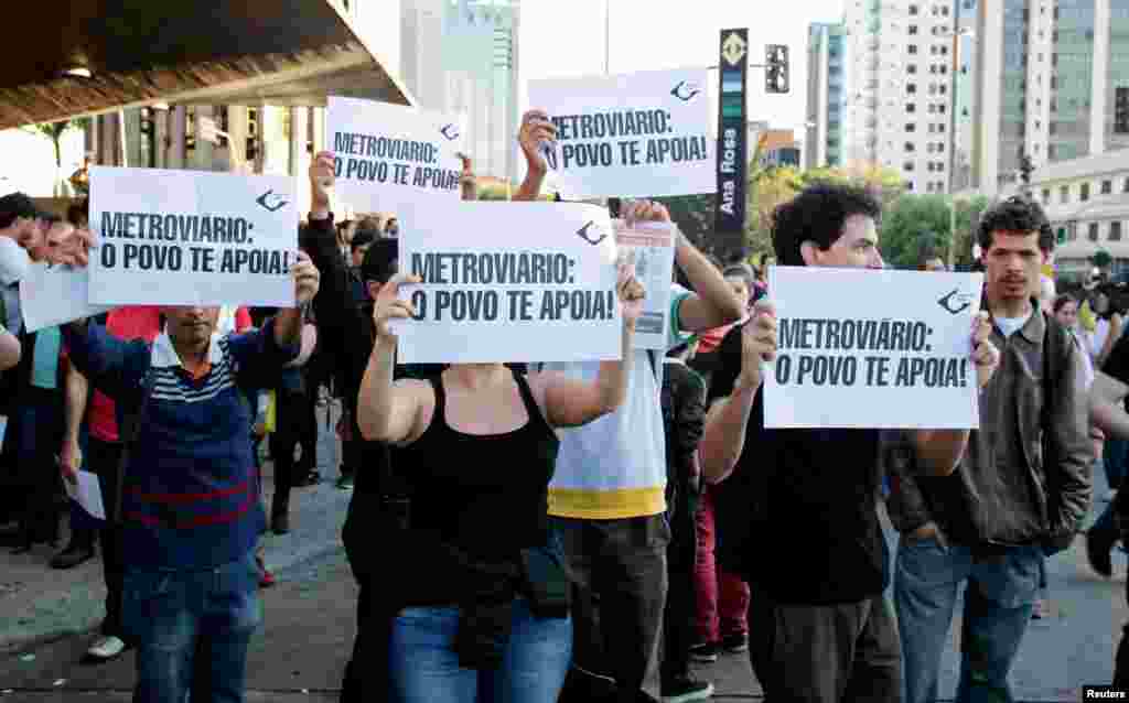 Warga membawa kertas bertuliskan &quot;Pekerja Metro: Rakyat mendukungmu,&quot; di luar stasiun kereta bawah tanah Ana Rosa pada pemogokan hari ke lima di Sao Paulo, Brazil (9/6).
