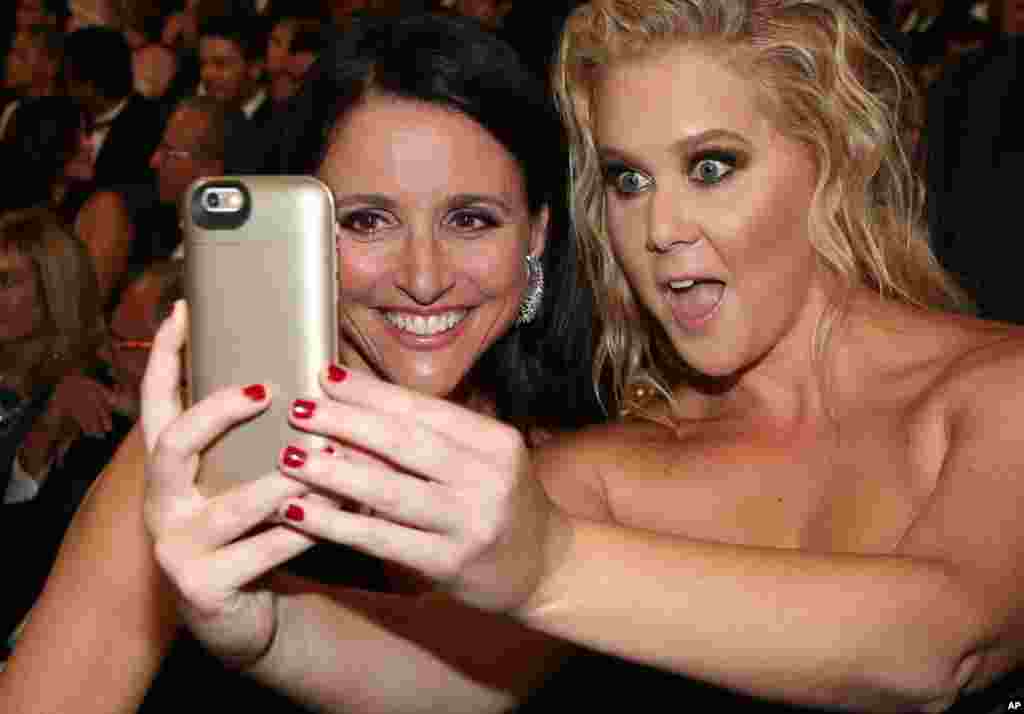 جولیا لوئیز (راست) بازیگر سریال &quot;ویپ&quot; و برنده جایزه بهترین نقش اول زن در سریال&nbsp; های کمدی، در حال گرفتن عکس سلفی با امی شومر در حاشیه مراسم اعطای جوایز امی ۲۰۱۵ &nbsp;