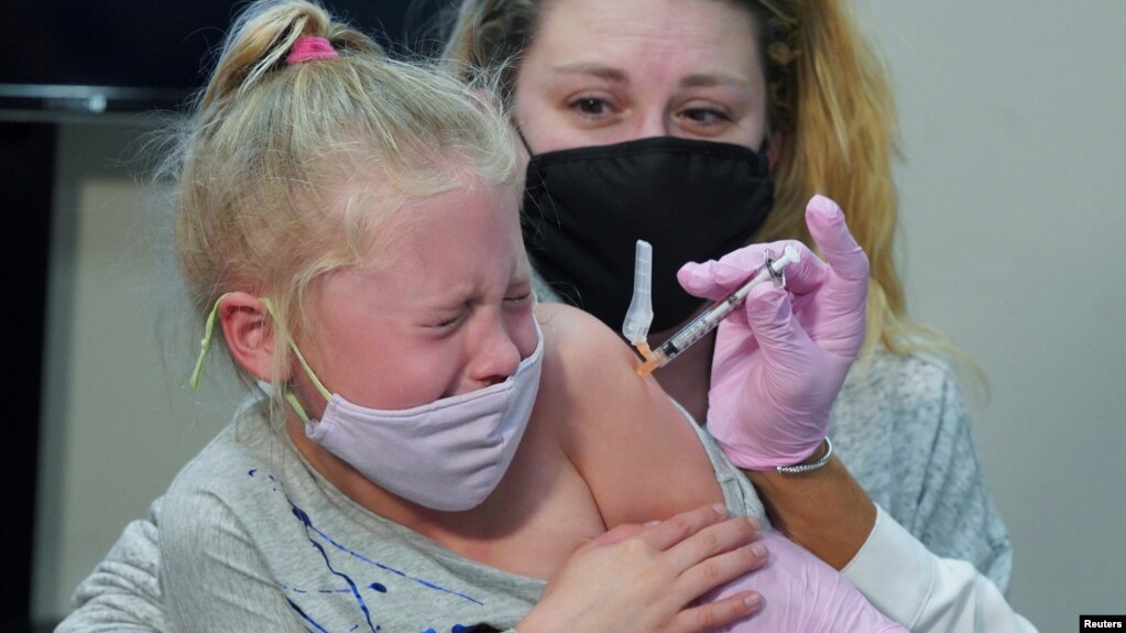 康乃迪戈州七岁的艾玛·英格丽坐在妈妈的怀里接种新冠疫苗（2021年11月3号）。 (photo:VOA)