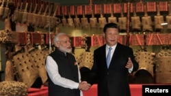 Chinese President Xi Jinping and Indian Prime Minister Narendra Modi shake hands as they visit the Hubei Provincial Museum in Wuhan, Hubei province, China, April 27, 2018.