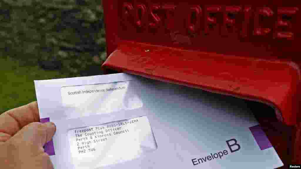 A postal vote for the Scottish Independence Referendum is dropped into a letter box in Moulin, Scotland, Sept. 12, 2014. 