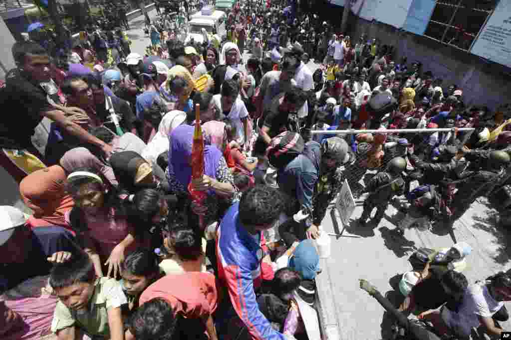 Villagers line up to board a truck after authorities ordered a forced evacuation of their village during a standoff in Zamboanga, Philippines, Sept. 13, 2013.