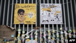 A placard showing a caricature of Kung Fu legend Bruce Lee (L) is displayed at the main protest site in the Admiralty district of Hong Kong, Oct. 23, 2014. 