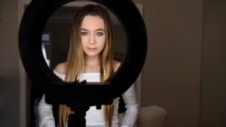 In this Feb. 28, 2018 photo, Matty Nev Luby poses for a photograph in front of a ring light she uses for her internet posts in Wethersfield, Conn. The high school gymnast’s popularity on the lip-syncing app Musical.ly, which merged this summer into the Ch