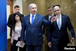 Israeli Prime Minister Benjamin Netanyahu, center, arrives to attend the weekly cabinet meeting in Jerusalem, March 17, 2019.