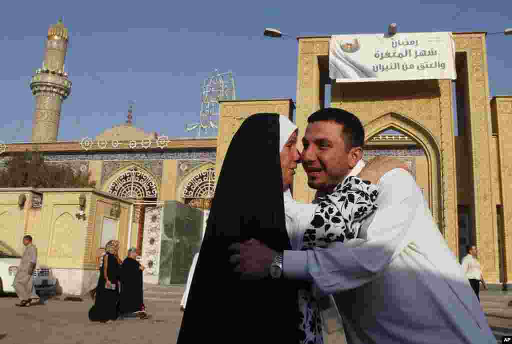 Iraqi Sunni Muslims exchange greetings after Eid prayers outside Abu Hanifa mosque at the first day of Eid al-Fitr prayers in the Azamiyah area of north Baghdad, Iraq, August 19, 2012. 