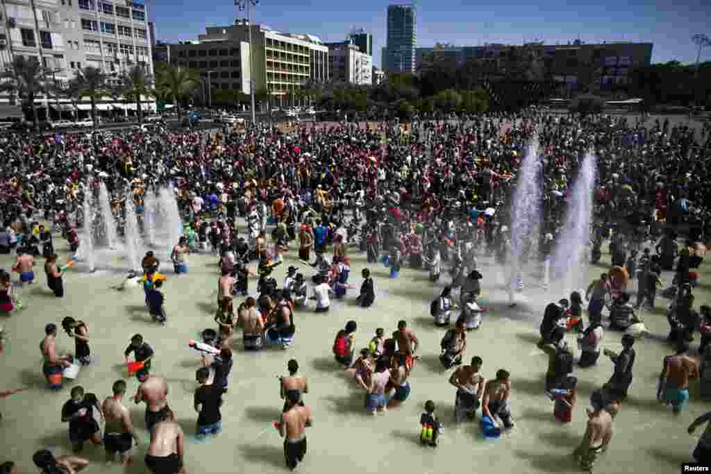 Dân chúng tham gia một cuộc chiến đấu nước tại Quảng trường Rabin ở Tel Aviv. Hàng ngàn người tham gia sinh hoạt được ưa chuộng hằng năm này. 