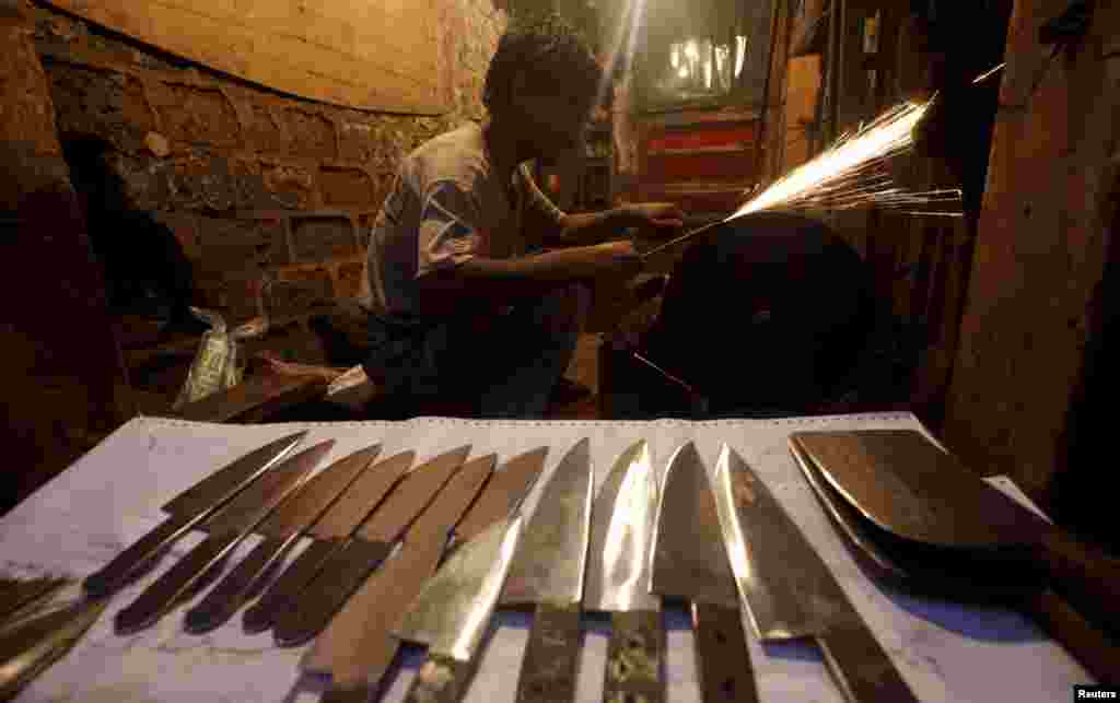 A man sharpens knives to be sold ahead of the Eid al-Adha festival, in Karachi, Pakistan, Sept. 22, 2015.