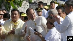 Philippine President Benigno Aquino III, center, is applauded by lawmakers after signing into law the Human Rights Victims Reparation and Recognition Act of 2013, Feb. 25, 2013.
