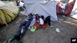 A Venezuelan refugee family rests outside a makeshift camp before going out to find any kind of work in Quito, Ecuador, Aug. 9, 2018.