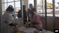 Des infirmières du ministère ougandais de la Santé passent au contrôle des passagers arrivant de la République démocratique du Congo, à l'aéroport d'Entebbe, à Kampala en Ouganda, le vendredi 8 août 2014.