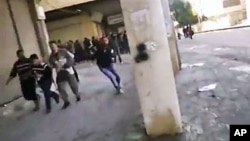 This image from amateur video purports to shows Syrian protesters running from gunfire in Hama, Syria, December 28, 2011.