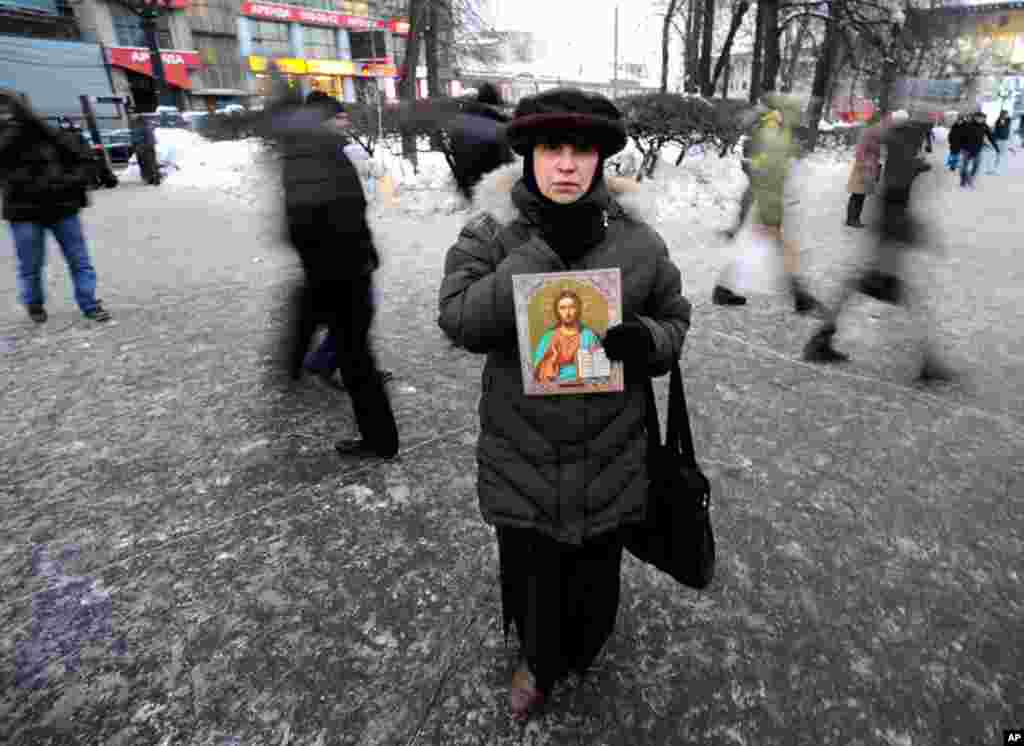 A woman holds a religious icon as she takes part in a rally to commemorate the victims of a bomb explosion at Domodedovo airport in central Moscow. (Reuters/Nikolay Korchekov)