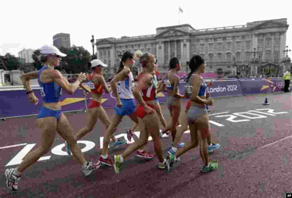Competitors in the women&#39;s 20-kilometer race walk pass Buckingham Palace at the 2012 Summer Olympics, Saturday, Aug. 11, 2012, in London.