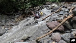 Rescuers carry the body of a victim after a flood hit Dua Warna waterfall in Sibolangit, North Sumatra, Indonesia, May 16, 2016.