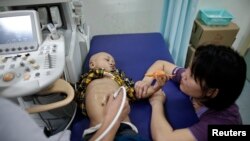 Four-year-old Niuniu, who has late-stage neuroblastoma, a malignant cancer of the nervous system, receives an ultrasound at the Shanghai Children's Hospital in Shanghai, May 30, 2013. 