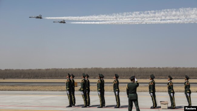 中国空军两架歼-11战机在辽宁沈阳一个机场低空飞行飞过一队中国士兵。 （2019年4月3日）