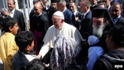 Le pape François, au centre, salue les enfants réfugiés à son arrivée au camp de ces derniers à Moria, sur l’ île de Lesbos, Grèce, 16 avril 2016. epa/ ORESTIS