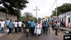 Un homme tient une croix catholique lors d'une manifestation près de l'église François De Sales, à Kinshasa, le 25 février 2018.
