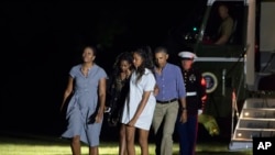 First lady Michelle Obama, from left, daughters Sasha Obama, Malia Obama and President Barack Obama return from a 16-day vacation to Martha's Vineyard, Mass., arriving at the White House in Washington, Sunday, Aug. 21, 2016.