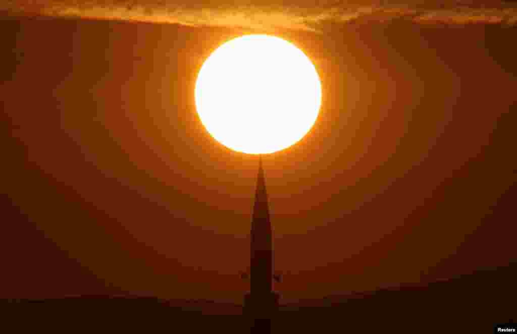 The sun rises above a mosque before the prayer for Eid al-Fitr in Lipljan, Kosovo.