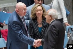 Russia's Ambassador to the United Nations Vassily Nebenzia, left, greets Palestinian Ambassador Riyad Mansour before a Security Council meeting on the situation between the Israelis and the Palestinians, June 1, 2018.