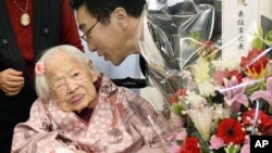 Misao Okawa, insan tertua dunia oleh Guinness World Records tahun 2013, menerima ucapan selamat dari Walikota Ward, Takehiro Ogura, dalam perayaaan hari ulang tahunnya yang ke-117 di sebuah panti lansia di Osaka, Jepang (4/3).