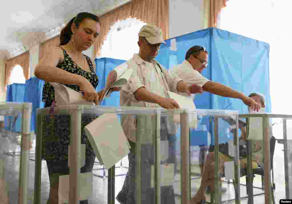 People cast their ballots during voting in a presidential election at polling station in Kyiv.