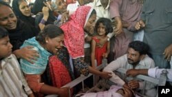 Pakistani family members mourn the death of a man shot dead amid unabated violence in Karachi, Pakistan, July, 8, 2011.