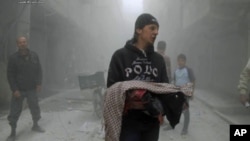 Ảnh do nhóm hoạt động chống chính phủ Aleppo Media Center (AMC) cung cấp, đã được xác định dựa trên nội dung và báo cáo của hãng tin AP, cho thấy một người đàn ông Syria ôm thi thể một đứa trẻ bị thiệt mạng trong một vụ không kích của lực lượng chính phủ tại Aleppo, ngày 15/4/2014.