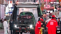 The car driven by a man who steered his car onto a busy Times Square sidewalk, killing a teenager and injuring nearly two dozen others, is removed by police and investigators from the crime scene area, May 18, 2017, in New York. 