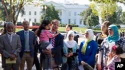 Dr. Zaher Sahloul dari masyarakat Suriah Amerika menggendong anak pengungsi Suriah dalam konferensi pers di depan Gedung Putih, menyerukan pemerintah Obama untuk berupaya lebih dalam mengatasi krisis di Suriah, September 2015