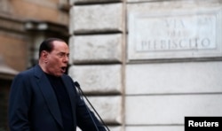 Former Italian Prime Minister Silvio Berlusconi speaks during a rally to protest his tax fraud conviction, outside his palace in central Rome, August 4, 2013.