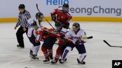 South Korea, wearing white uniforms, and North Korean players compete during their IIHF Ice Hockey Women's World Championship Division II Group A game in Gangneung, South Korea, April 6, 2017. 