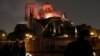 Firefighters douse flames from the burning Notre Dame Cathedral as people look on in Paris, France, April 15, 2019.