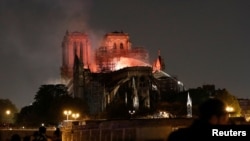 អ្នក​ពន្លត់​អគ្គិភ័យ​ព្យាយាម​ពន្យល់​អណ្តាត​ភ្លើង ដែល​កំពុង​ឆាបឆេះ​វិហារ Notre Dame នៅ​ក្នុង​ក្រុង​ប៉ារីស ប្រទេស​បារាំង កាលពី​ថ្ងៃទី១៥ ខែមេសា ឆ្នាំ២០១៩។