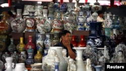 A vendor sits amongst his collection of ceramics as he waits for customers at a small market in central Beijing September 8, 2012. China's annual rate of consumer inflation ticked up t o 2.0 percent in August from July's 30-month low of 1.8 percent, offic