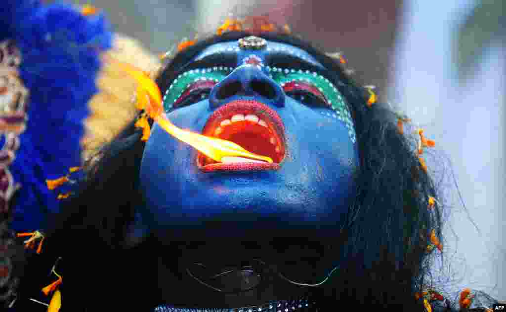 인도 알라하바드에서 열린 라마신 생일 기념행사인 &#39;람 나바미&#39; 축제에서 한 예술가가 힌두신 &#39;칼리&#39; 복장을 하고 공연을 펼치고 있다.