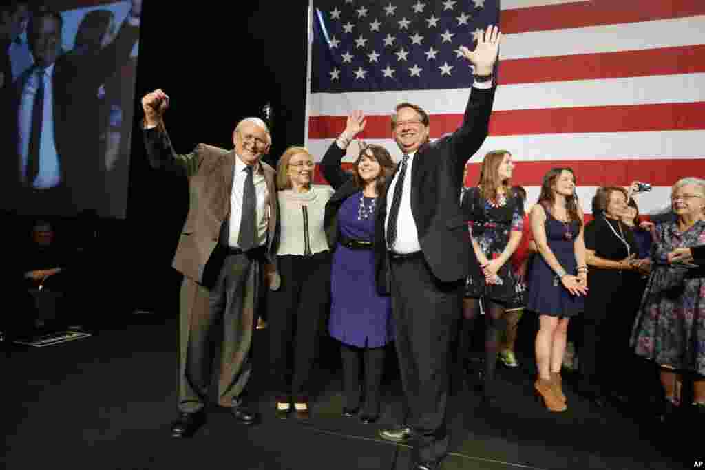 U.S. Senate elect Gary Peters stands with his wife Colleen, center, with retiring Sen. Carl Levin, Levin's wife Barbara Halpern-Levin, and Sen. Debbie Stabenow, right, after Gary Peters addressed supporters in Detroit, Tuesday, Nov. 4, 2014. Peters defeat