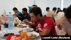 FILE: Algerians break their fast at a charity food distribution center by humanitarian association Ihcene on the outskirts of Algiers July 30, 2013. Ihcene launched a charity food distribution center during Ramadan, the holiest month in the Islamic calendar.
