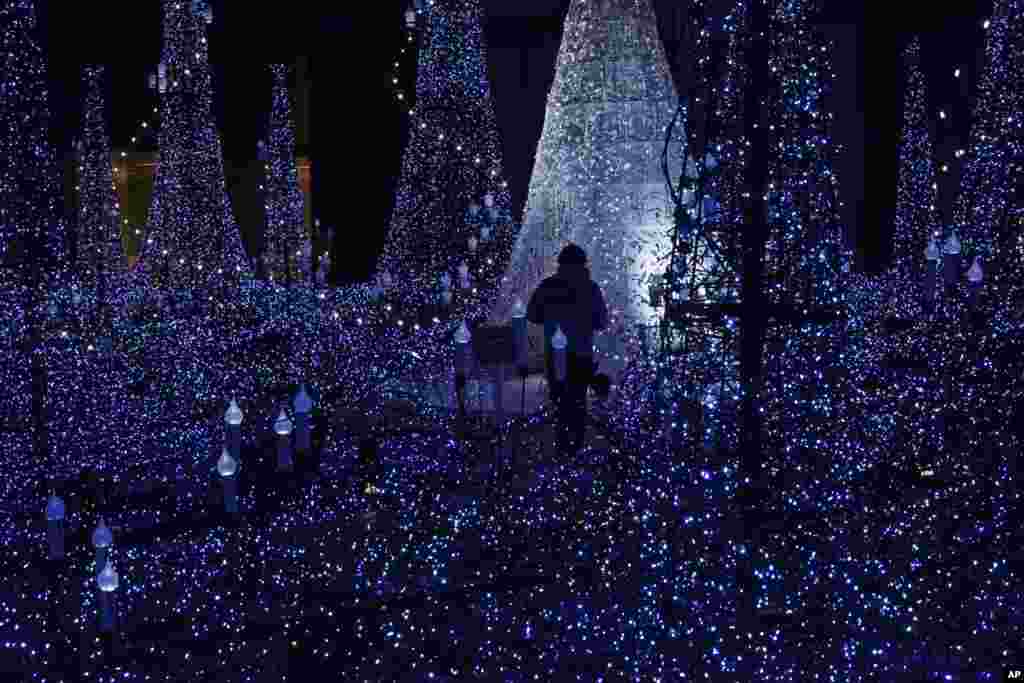 A staff walks through the annual year end illumination in Shiodome district in Tokyo, Japan.