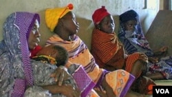 FILE - African women waiting for medical care.