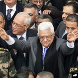 Palestinian President Mahmoud Abbas, center, gestures during a rally in the West Bank city of Ramallah, 25 Jan 2011