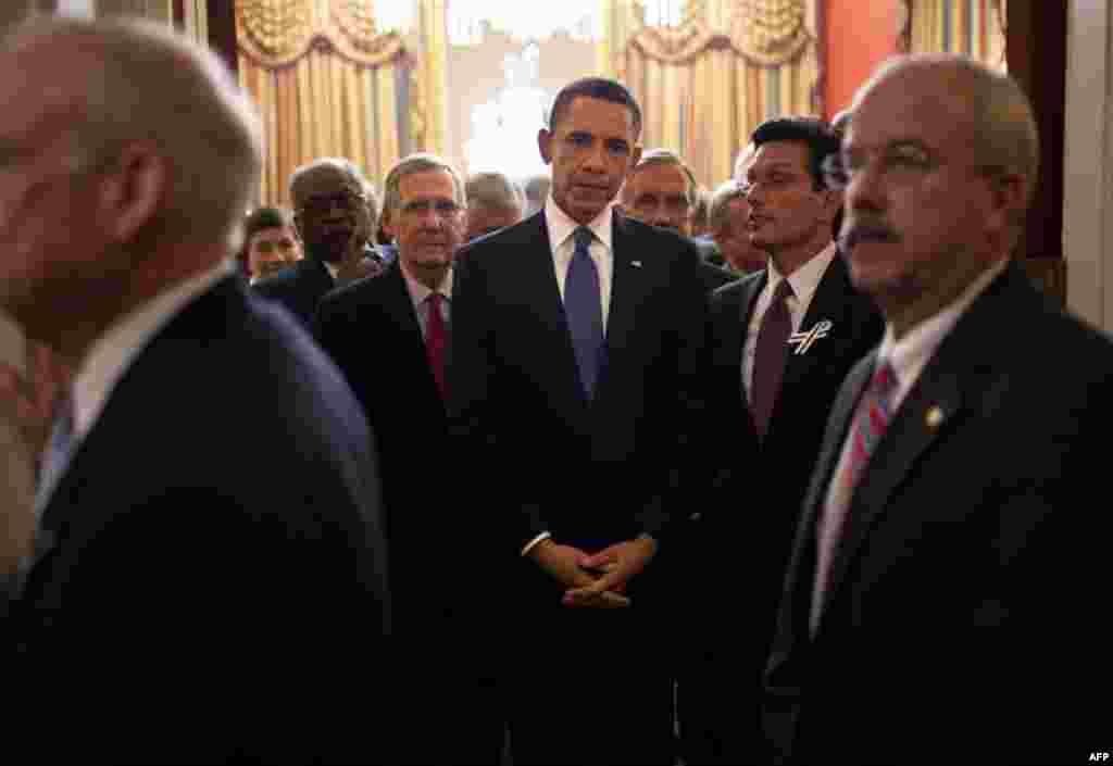 January 25: President Barack Obama stands with Members of Congress in House Speaker John Boehner's ceremonial office as Bill Livingood, House Sergeant at Arms, left, and Terrance Gainer, Senate Sergeant at Arms, right, prepare to escort them onto the floo