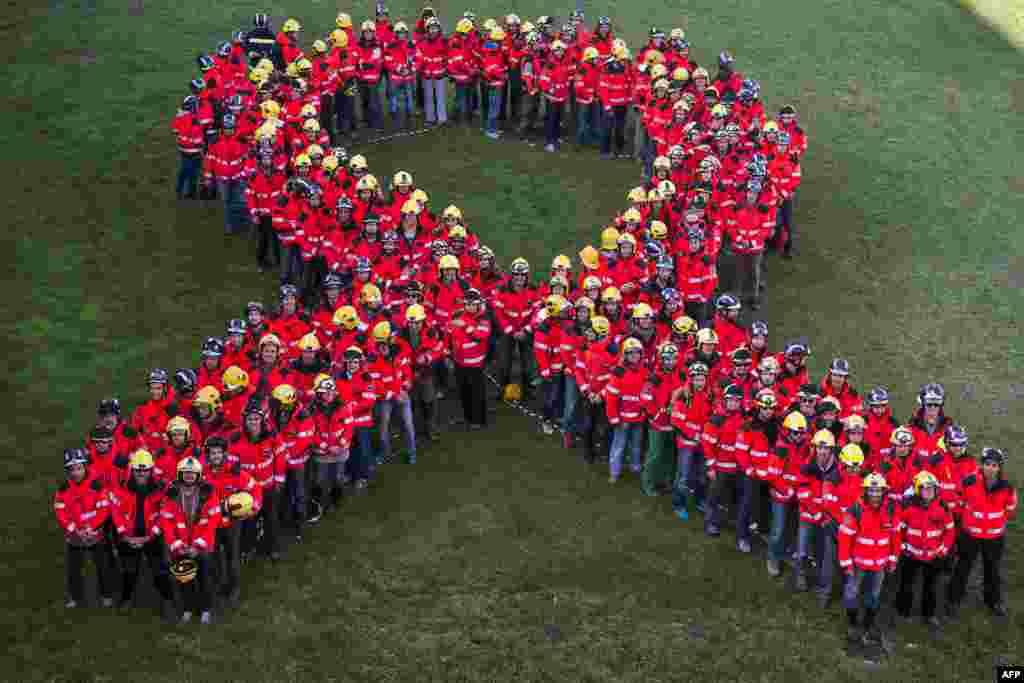 Firefighters stand to form the shape of a giant ribbon at the Montjuic Castle in Barcelona on November 20, 2017 during a protest calling for the release of jailed Catalan separatist leaders.