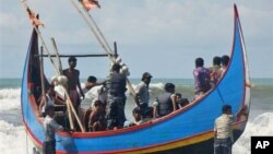 Penjaga pantai Bangladesh memeriksa pengungsi muslim Rohingya yang selamat dari kapal mereka yang tenggelam di lepas pantai Bangladesh (7/11).