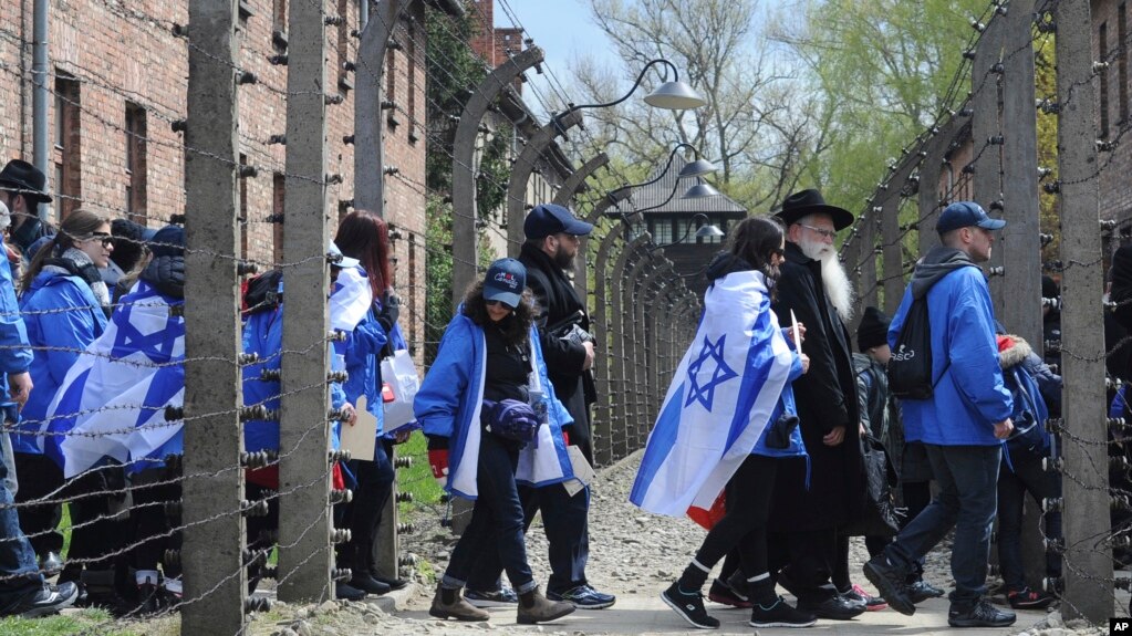 Participants of the yearly March of the Living walk through a barbed wire fence in the former German Nazi Death Camp Auschwitz-Birkenau, in Oswiecim, Poland, April 24, 2017. 