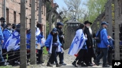 Participants of the yearly March of the Living walk through a barbed wire fence in the former German Nazi Death Camp Auschwitz-Birkenau, in Oswiecim, Poland, April 24, 2017. 