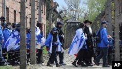 Participants of the yearly March of the Living walk through a barbed wire fence in the former German Nazi Death Camp Auschwitz-Birkenau, in Oswiecim, Poland, April 24, 2017. 