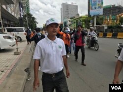 លោក ​ជុំ ហួត​ ដើរ​នៅពីមុខក្រុមអ្នកតវ៉ាសុំ​ឲ្យដោះលែង​លោក​ រ៉ុង ឈុន​ ទីក្រុងភ្នំពេញ ថ្ងៃទី​៣​ ខែ​សីហា​ ឆ្នាំ​២០២០។ (ហ៊ុល​ រស្មី/វីអូអេ)​